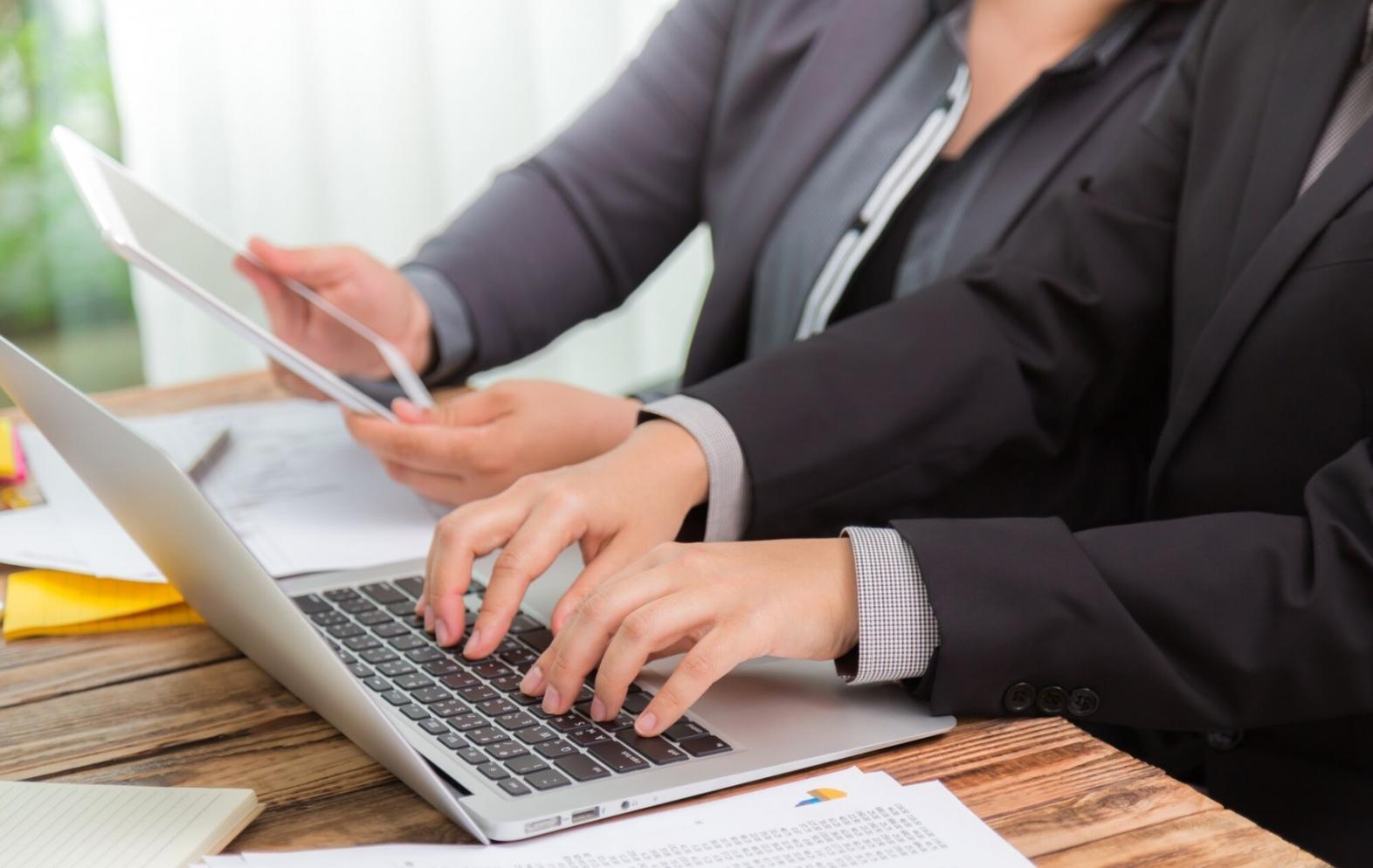 Estudiante revisando documentos financieros con calculadora y gráficos en escritorio